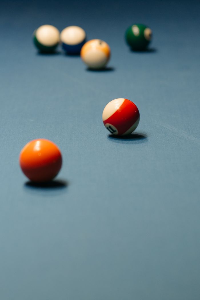Several billiard balls on a pool table surface, focusing on gameplay and precision.